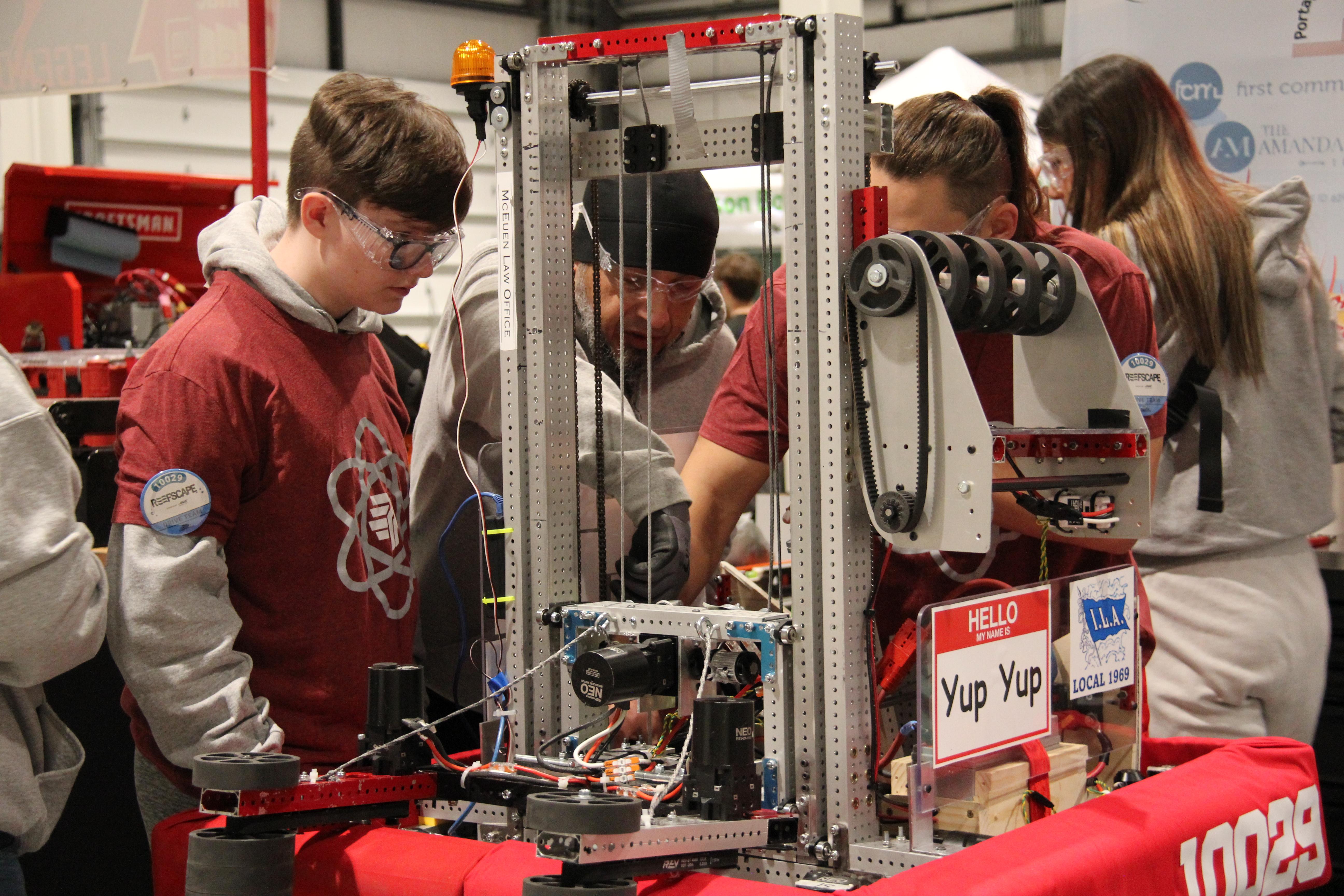 Team members inspecting robot after match